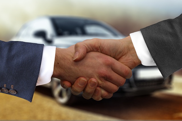Handshake over a car title, representing Velocity Drive's transparent pricing and trustworthy dealings with customers.